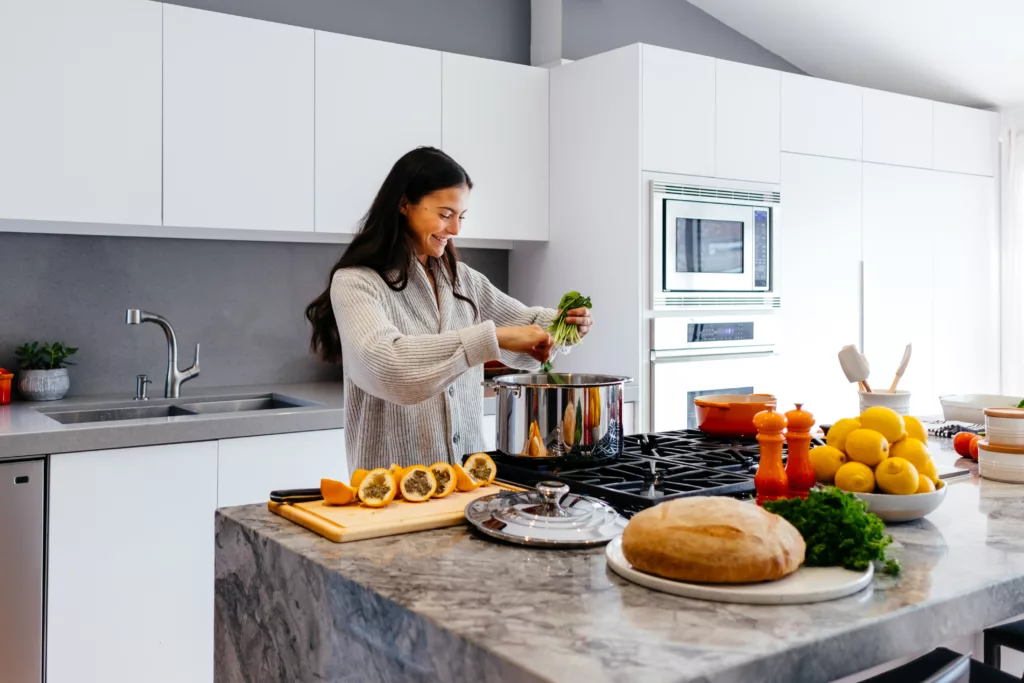 woman smiling while cooking