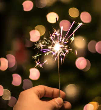 bokeh photography of person holding fireworks