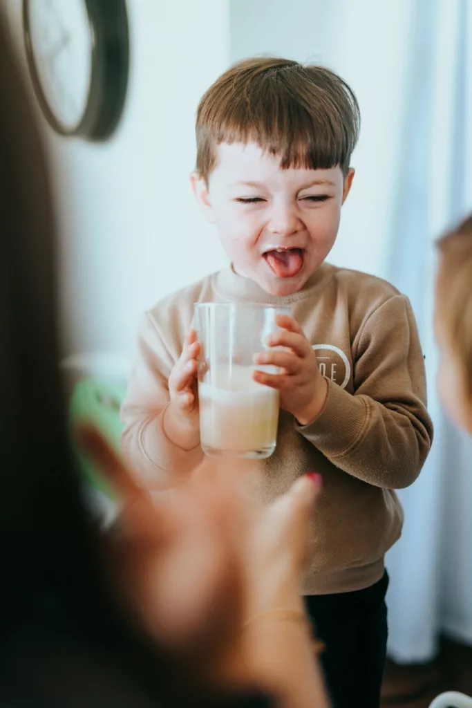 boy in brown long sleeve shirt holding clear glass jar