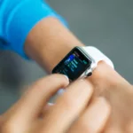 person wearing silver Apple Watch with white Sport Band