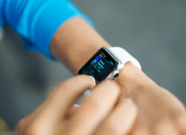 person wearing silver Apple Watch with white Sport Band